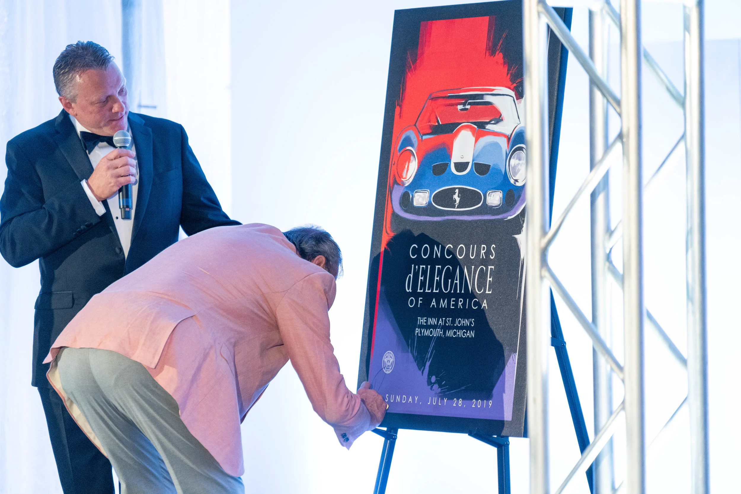 Ex-Formula 1 Race Car Driver and Commentator David Hobbs signs the Live Auction art piece by CCS student, Fabrizio Orsidepaula.