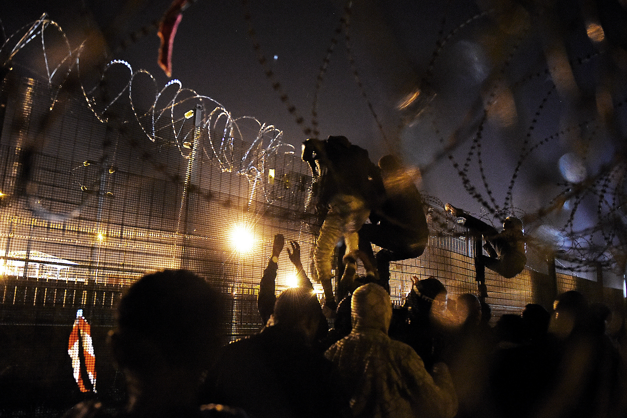 Refugees in Calais climb barbed wire fences to try and make their way onto trucks boarding the Eurotunnel trains and heading to the UK. 