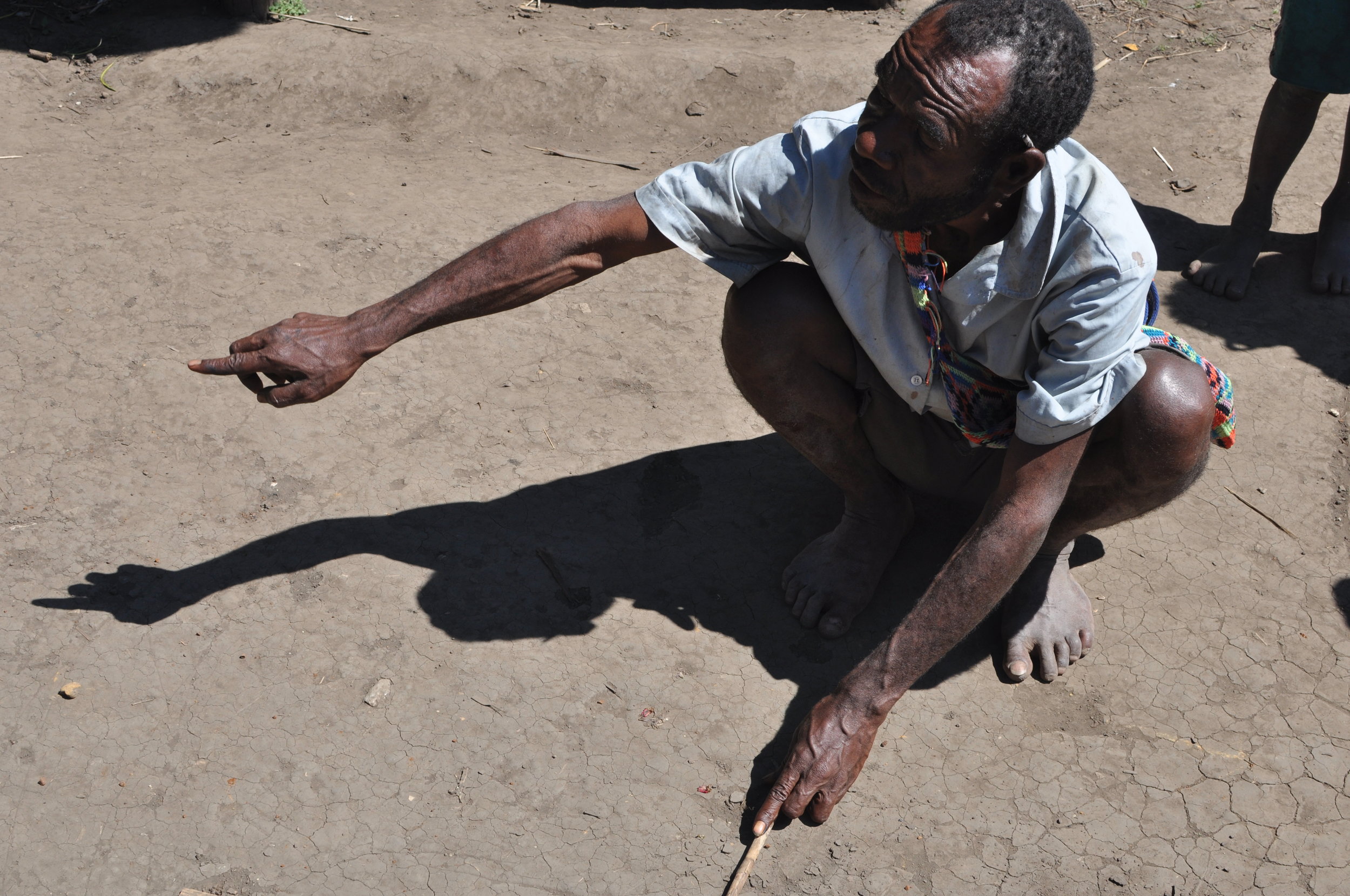  A man explains a timeline of Yupno history, recently scratched into the dirt. Gua, 2009. 