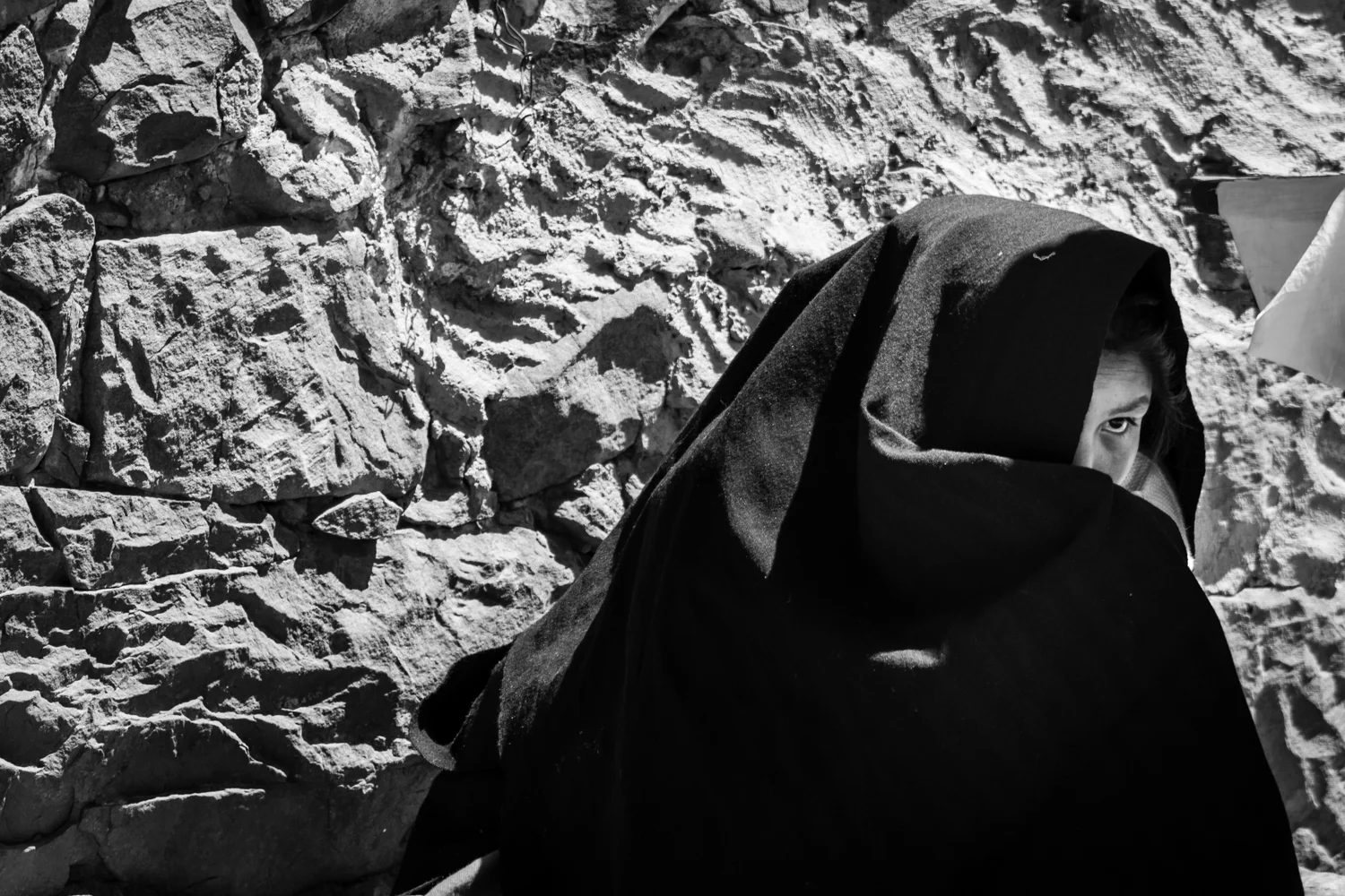 A girl protects herself from strong sun rays. Lake Titicaca is the highest navigable lake in the world (more than 3.500m - 11,483 ft - on sea level) and on the hills of Taquile island the altitude surpasses 4.000m - 13,123ft.