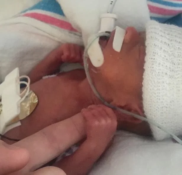 Kai holding dad's finger.JPG