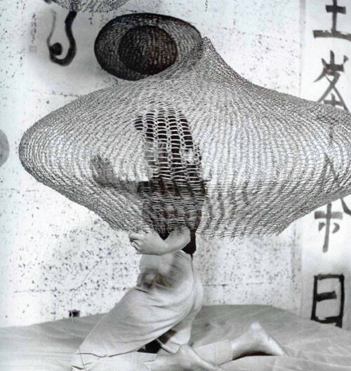 Cunningham, Imogen. “Untitled (Ruth Asawa on bed kneeling inside looped wire sculpture), 1957”. Gelatin silver print. Gift of Ruth Asawa and Albert Lanier. Achenbach Foundation. 2006. 114.4. San Francisco.