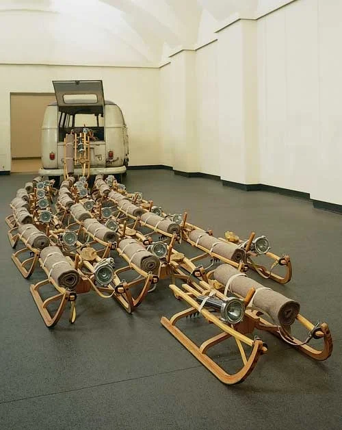 Joseph Beuys - Sürü (1969) 20 tane kızak yardıma ihtiyacı olanları kurtarmak üzere dönemin barış sembolü Volkswagen minibüsten çıkmaktadırlar. Kızaklarda, kurbanların önlerini aydınlatması için fenerler ve yaralarını iyileştirmek için keçeden battaniyeler vardır. 