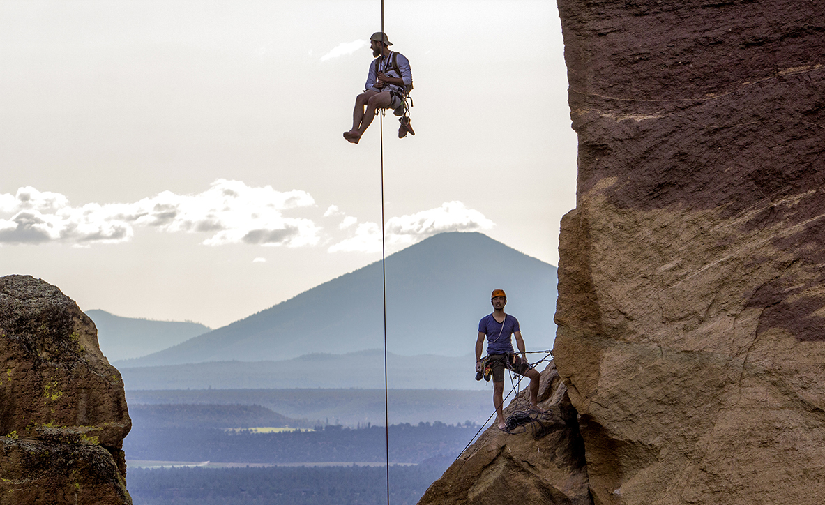  A rock climber descends down from the rock known as "Monkey Face" as another climbers looks on at Smith Rock State Park. Monkey Face is a 350 foot pillar, that resembles a monkey from the correct angle. The pillar contains several of the most diffic