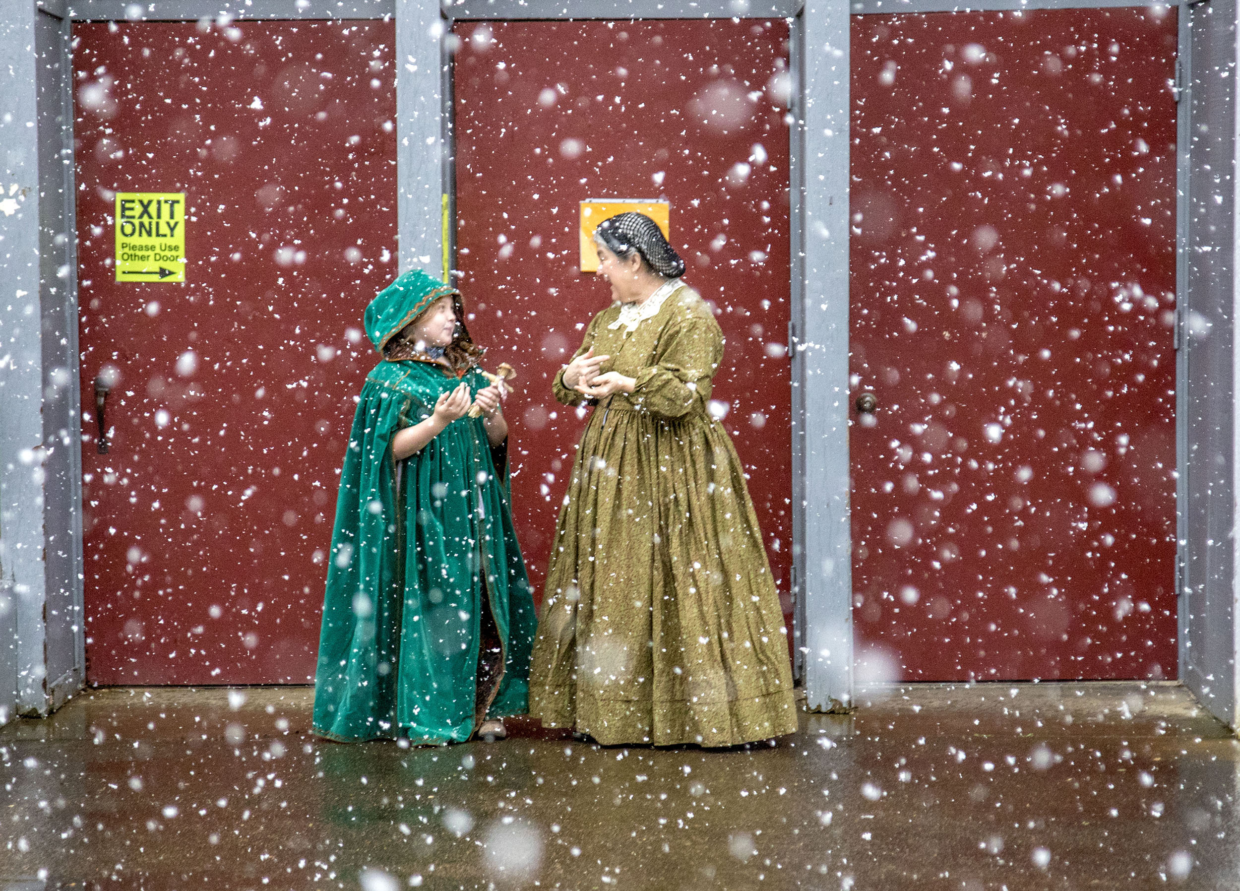  Hailey McKendrick, 7, and Lisa Ponder step outside the Frontier Heritage Fair to watch a rare snowfall in Eugene, Ore., on Sunday, Feb. 19, 2018. The Heritage Fair brought old fashioned clothing, art and tools to 21st century Eugene. Ponder attended