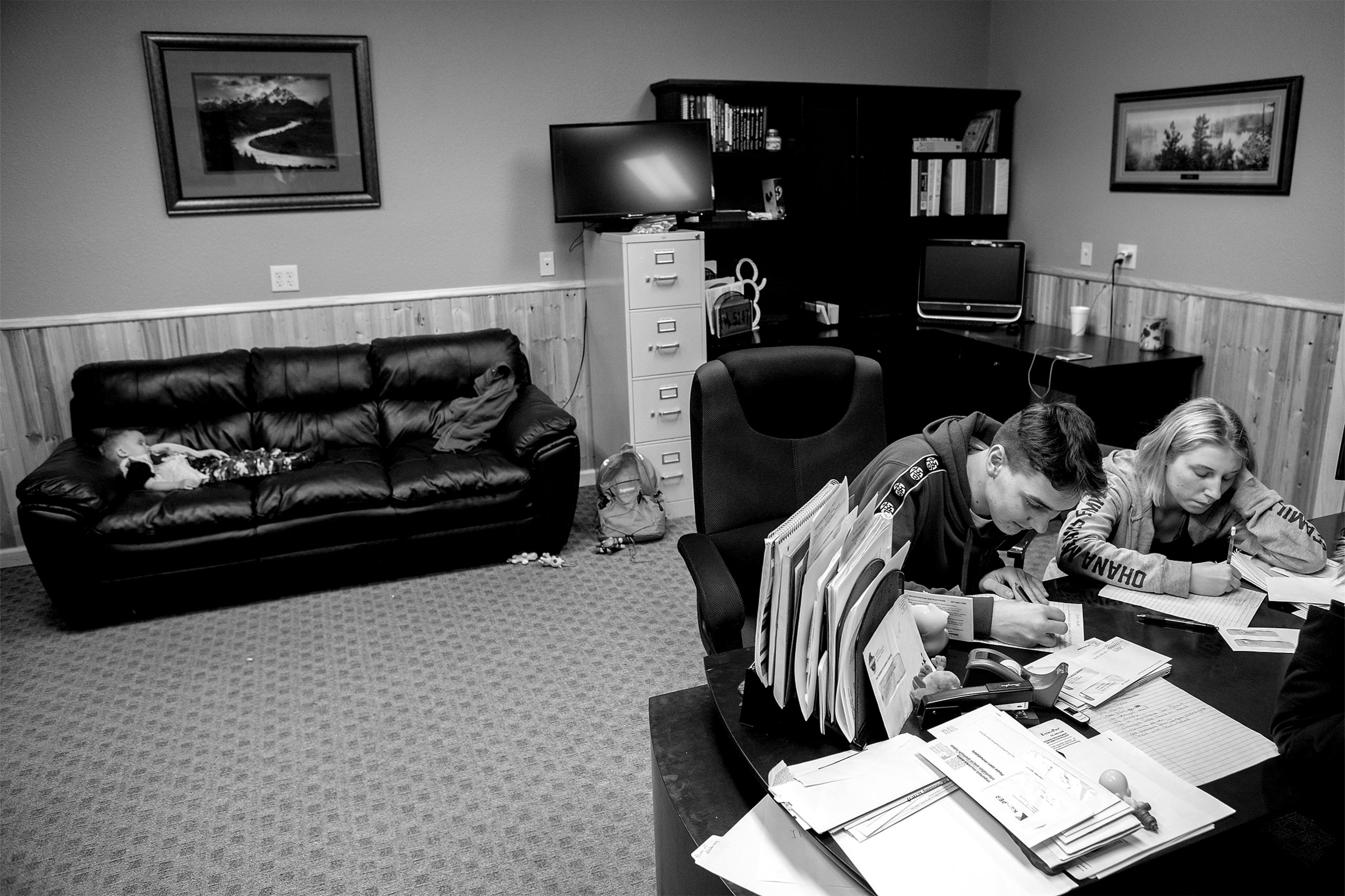  Sergey, 16, and Tanya, 15, write letters at Robert and Janelle Pfeil's workplace while Rayden Pfeil, 2, takes a nap on the couch. With the Pfeil's other kids at school during the day after the holiday breaks, the Ukraine orphans are left to entertai