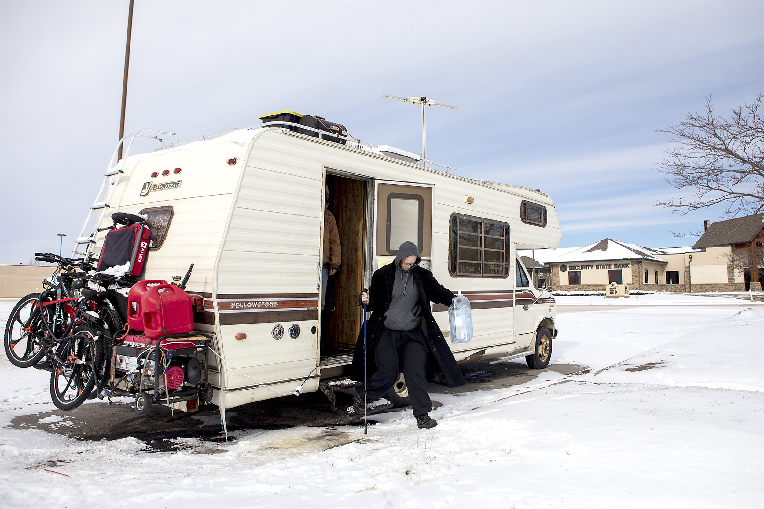  Andrea and Jeff exit their mobile home for a trip to Flying J's to get water. The family hopes to be able to travel from place to place after their home is repaired. 