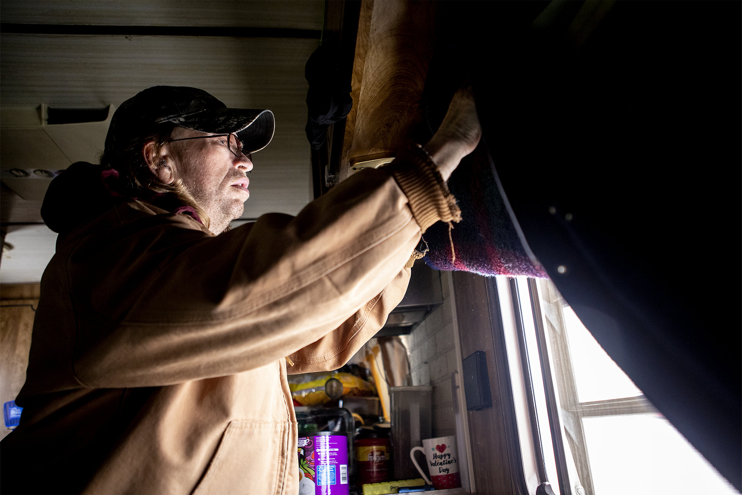  Jeff lifts the curtains of their home. During the recent cold that hit Gillette they ended up with ice on their windows and inch thick. The family relies one a heater and propane tanks to keep them and the mobile home warm during the winter. 