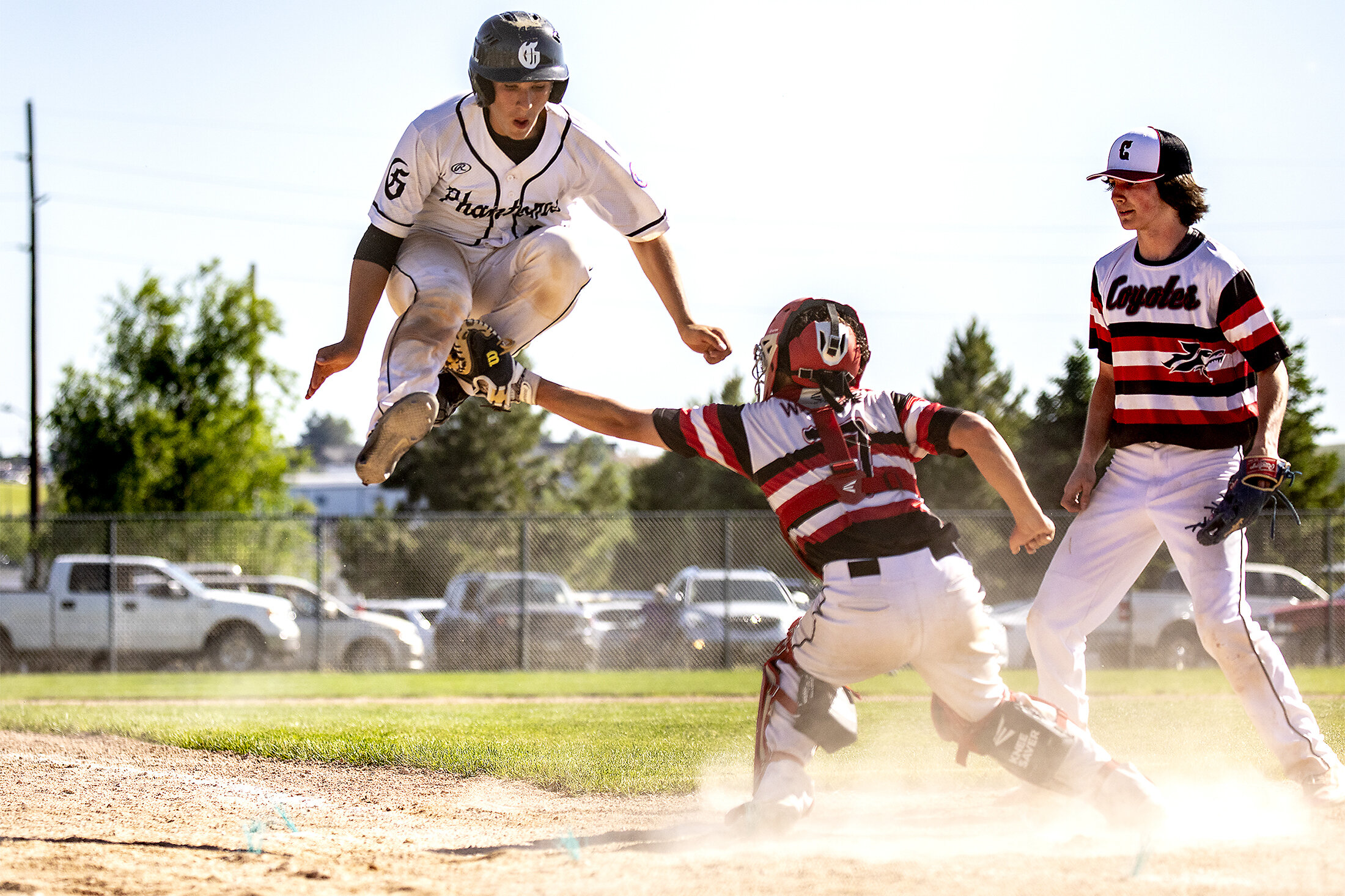  Gillette Phantoms' Kalub Balzer leaps into the air as he attempts to make it onto home base on Friday, June 28, 2019. Blazer was declared safe after the ball was dropped. 