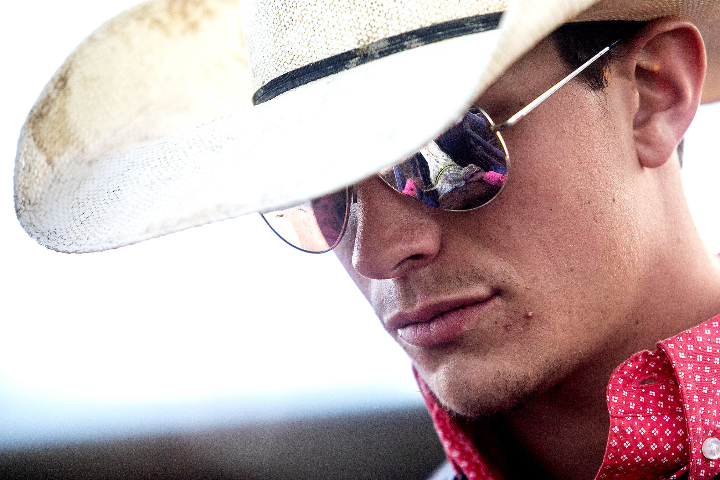  Ben Kukowski's horse is reflected in his glasses as he sits in the chute and prepares for his ride in the saddle bronc competition on Friday, June 7, 2019. 