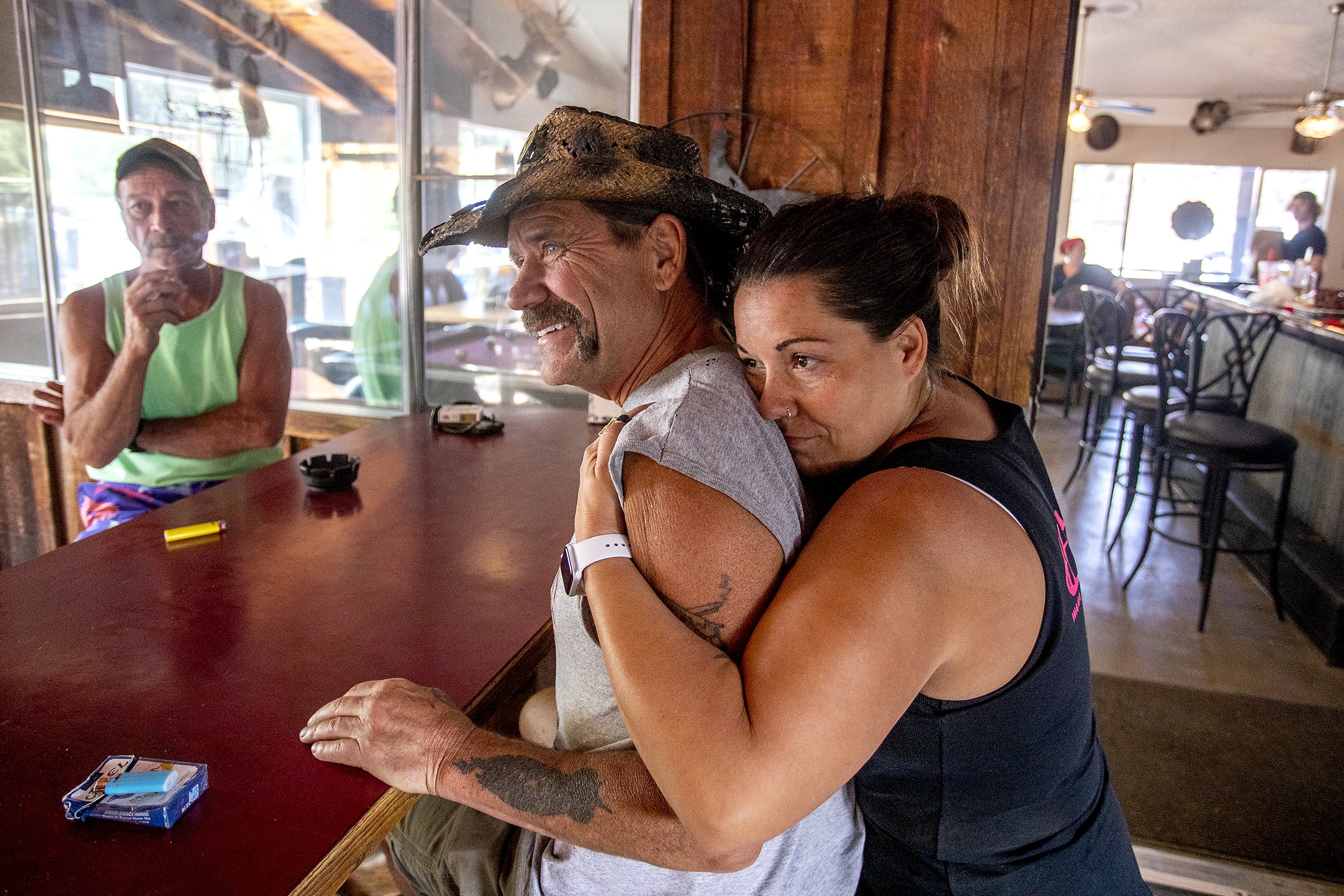  Sharon Barber embraces her father Cory James as they prepare food and gather up donations of food and water at the Waha Bar and Grill on Saturday. James, who owns the Waha Bar and Grill, was forced to evacuate his home on Friday night as firefighter