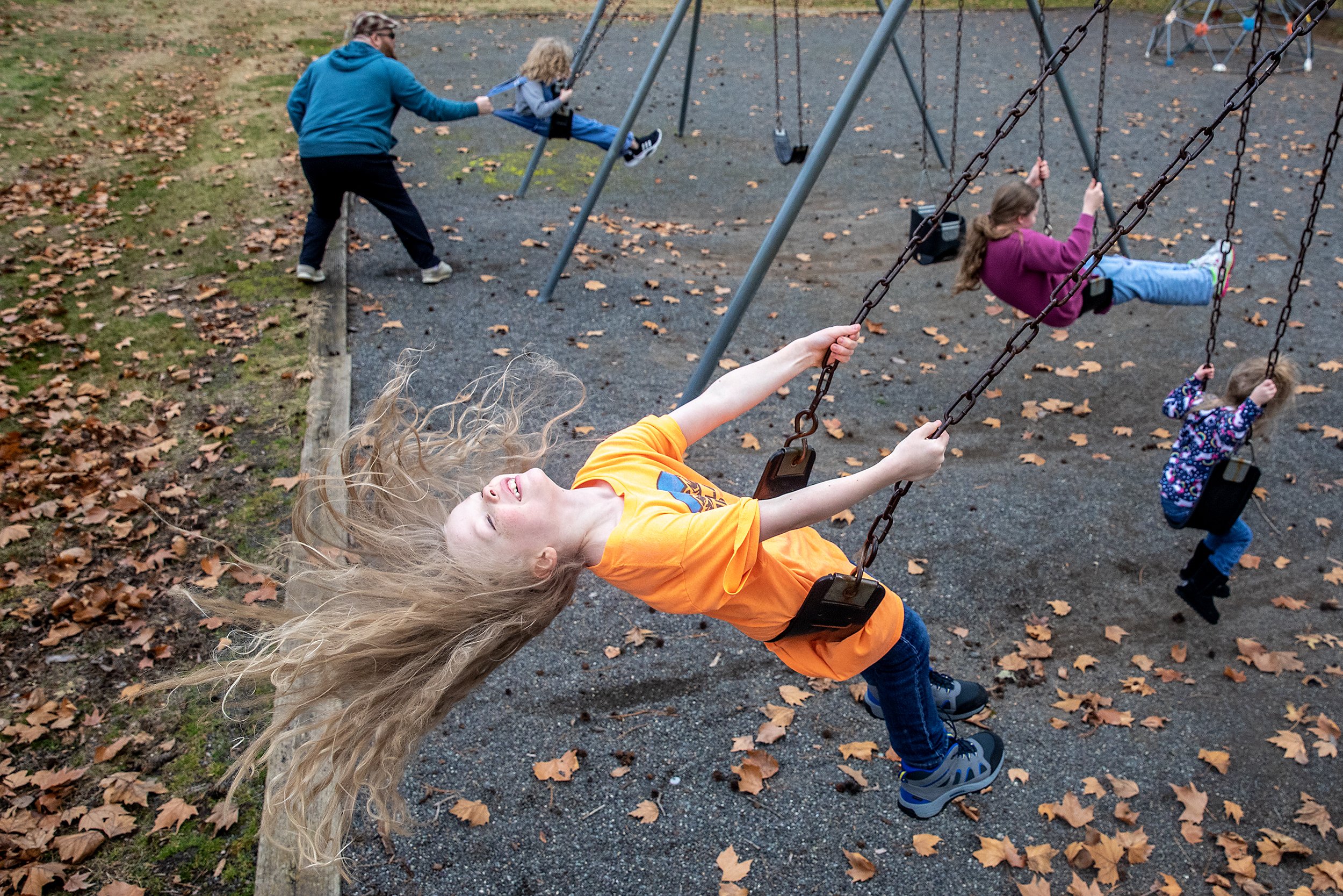  Atticus Bowen, 9, tilts his head back letting his hair fly as he swings with siblings Charlotte Bowen, 3, counter clockwise from right, Tennyson Bowen, 12, Isleik Bowen, 5, as father Michael Bowen pushes them Thursday, Feb. 1, 2024, at Swallows Park