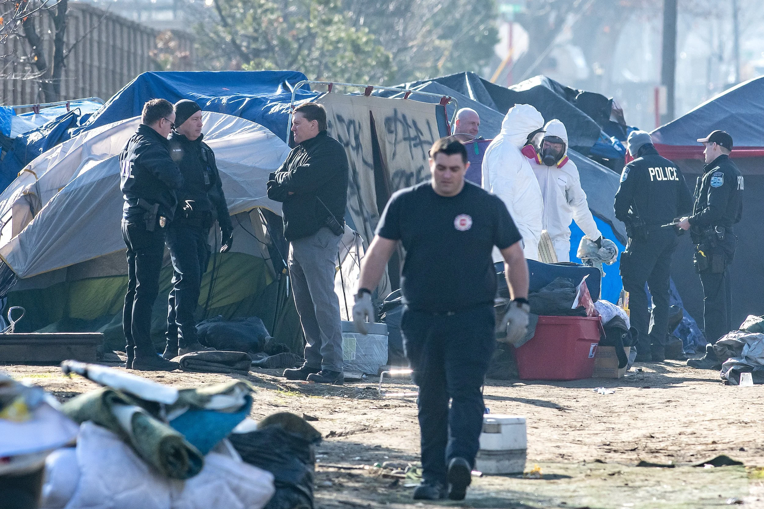  Members of the Clarkston Police Department, including Police Chief Joel Hastings, left of center, Clarkston Fire Department and Disaster Response work to clean up the homeless camp behind Walmart on Tuesday, Feb. 13, 2024, in Clarkston. 