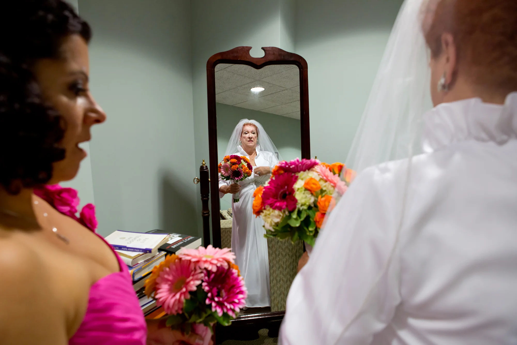 Bridesmaid Pam Devos helps Joyce adjust her gown before the wedding ceremony at Sacred Heart Cathedral.