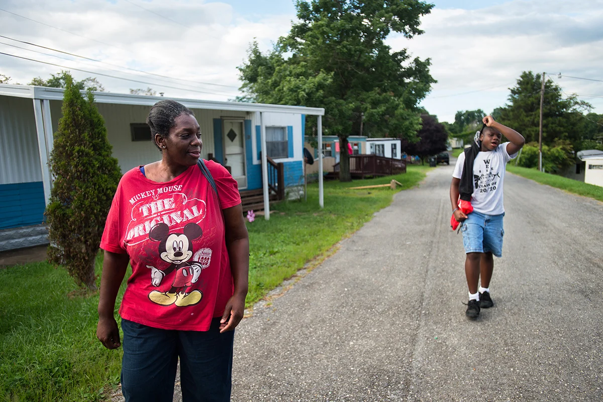 Ruby and her son walk to the bus stop from their home in Brentwood Mobile Home Park. Ruby cannot afford a car, so she uses the bus as her main source of transportation.