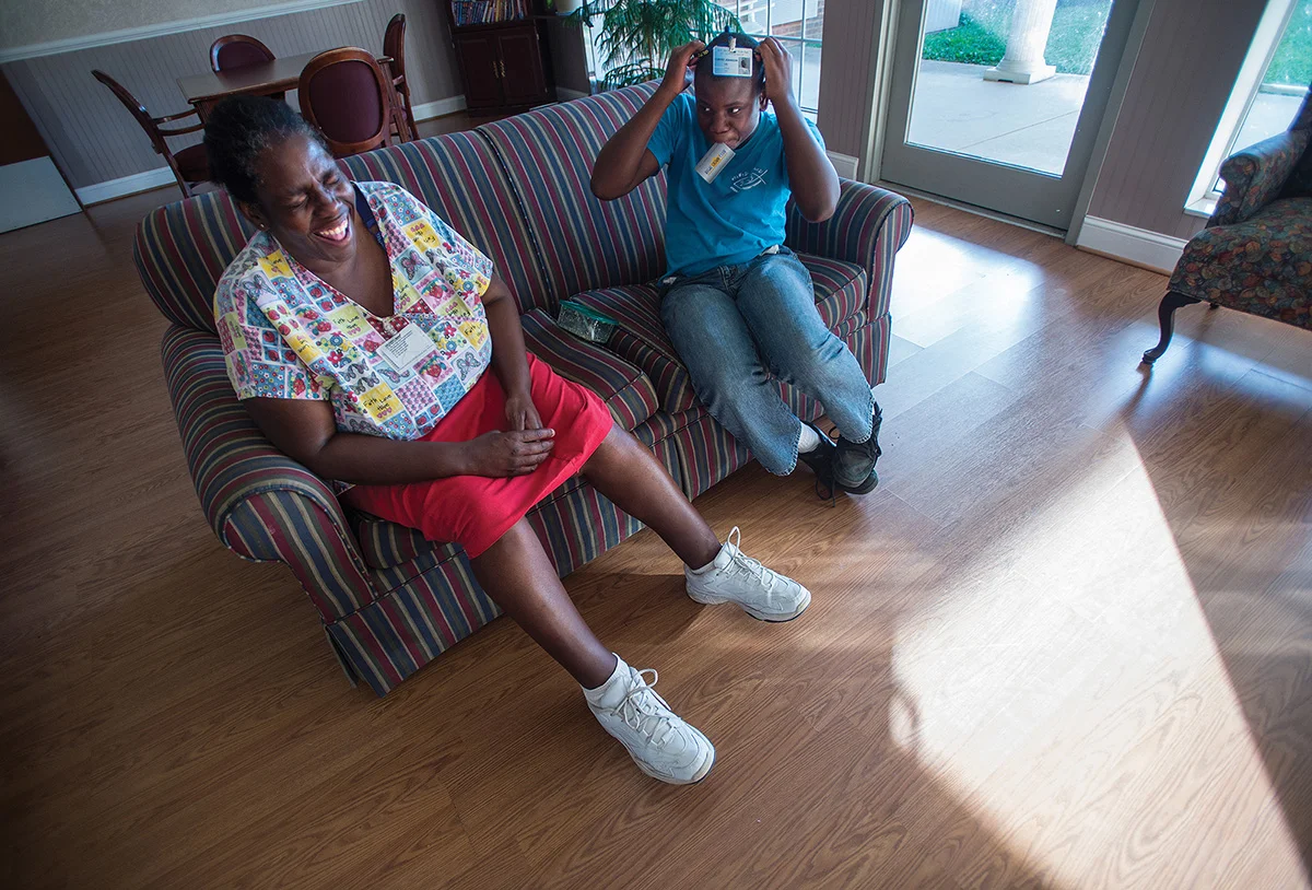 Cortez makes his mom laugh as he places a lanyard over his head during a break from her work at The Carrington. Cortez often visits Ruby at the nursing home after school and waits for her until she finishes her shift.