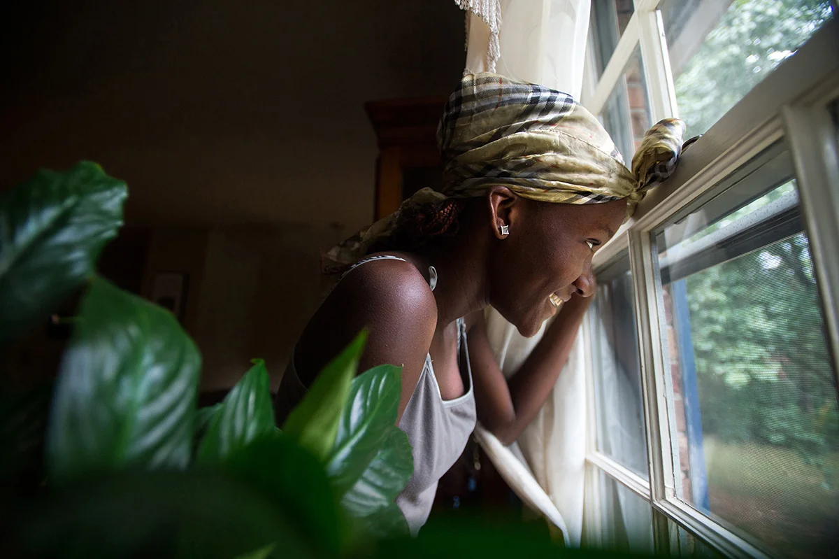 Promise Guy, 13, looks out the window at her friend, Sahara McKnight, 12, as she explores the outdoors after they arrived at their host family's home in Madison, Heights, Va.