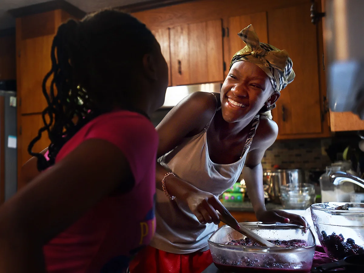 Promise and Sahara share a laugh while preparing blackberry cobbler with fresh berries they picked earlier that morning at Morris Orchard.