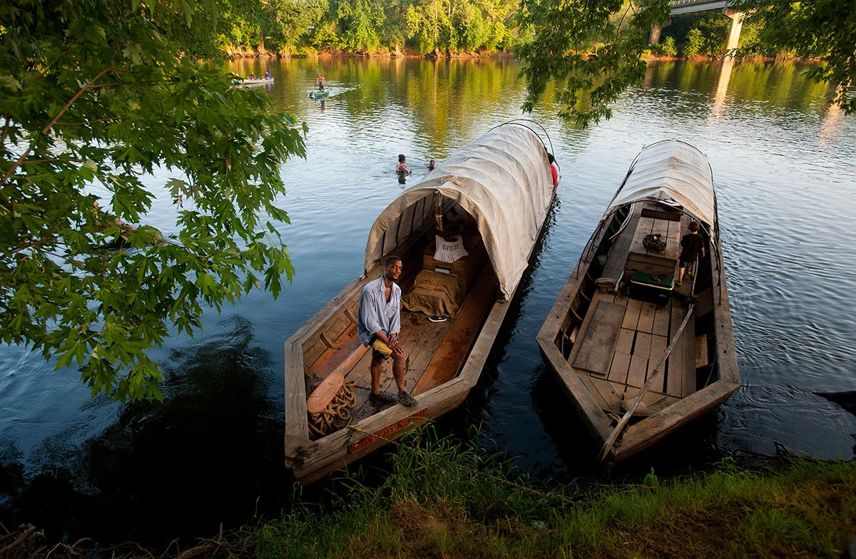 Chris Patillo stands on the edge of the Fine Creek Mill batteau after arriving in Scottsville, Va. during the James River Batteau Festival.