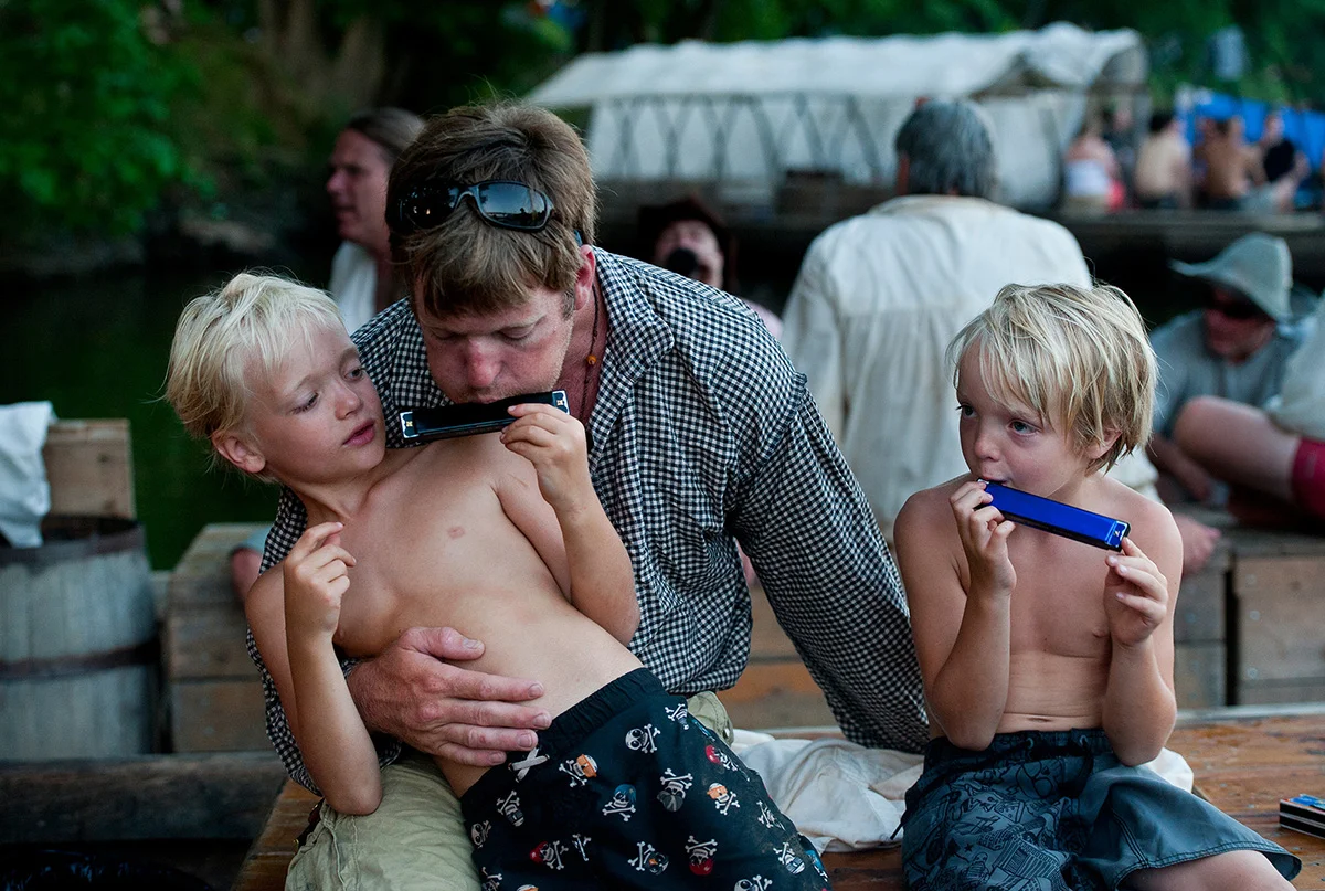 William Davis plays the harmonica with his two sons, Michael, 7, (left) and Ashby (5) after arriving in Scottsville, Va.
