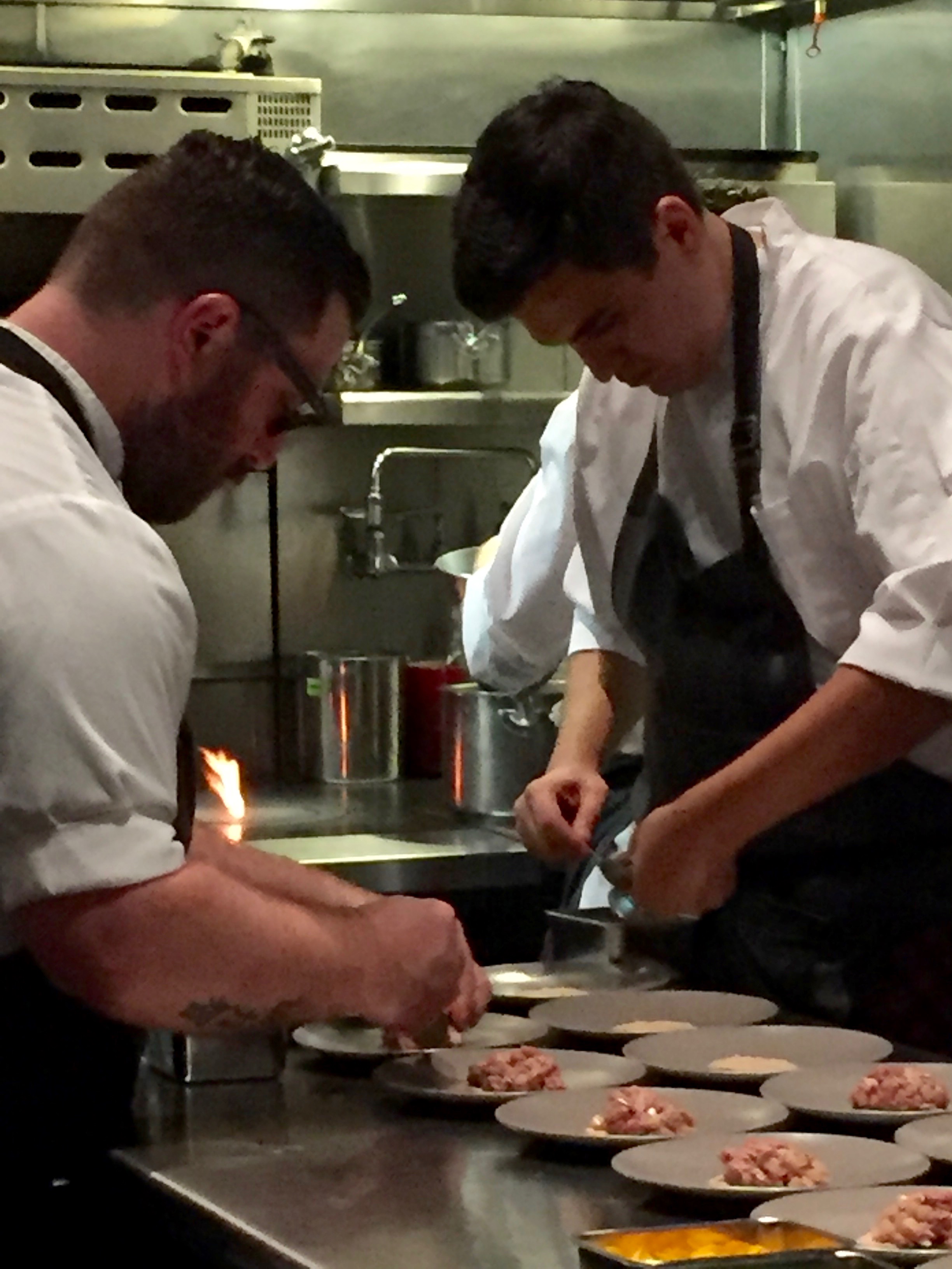 Chef David Berzalay on the left prepping a plate