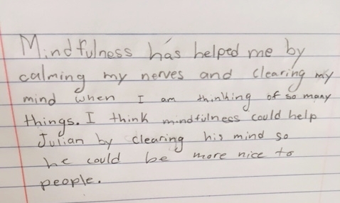 This is a journal entry by a 4th grade student promoted by the sentences stems "Mindfulness has helped me at school or at home by..." and "I think mindfulness could help (character in the book Wonder) by..."