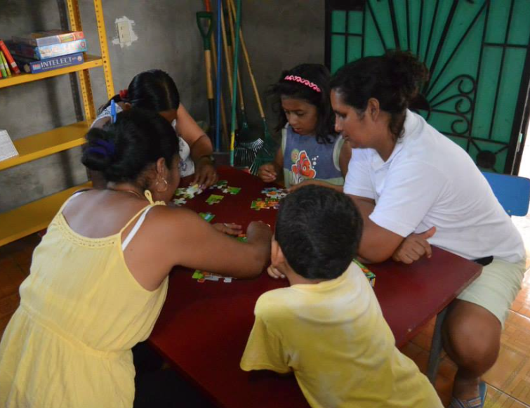 Moms and Kids enjoying jigsaw puzzles at the Mns. Romero Community Library created by Izote
