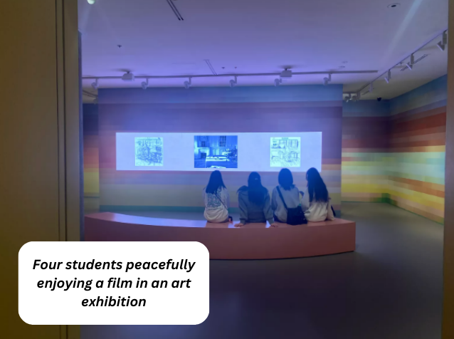 Four students peacefully enjoying a film in an art exhibition.png