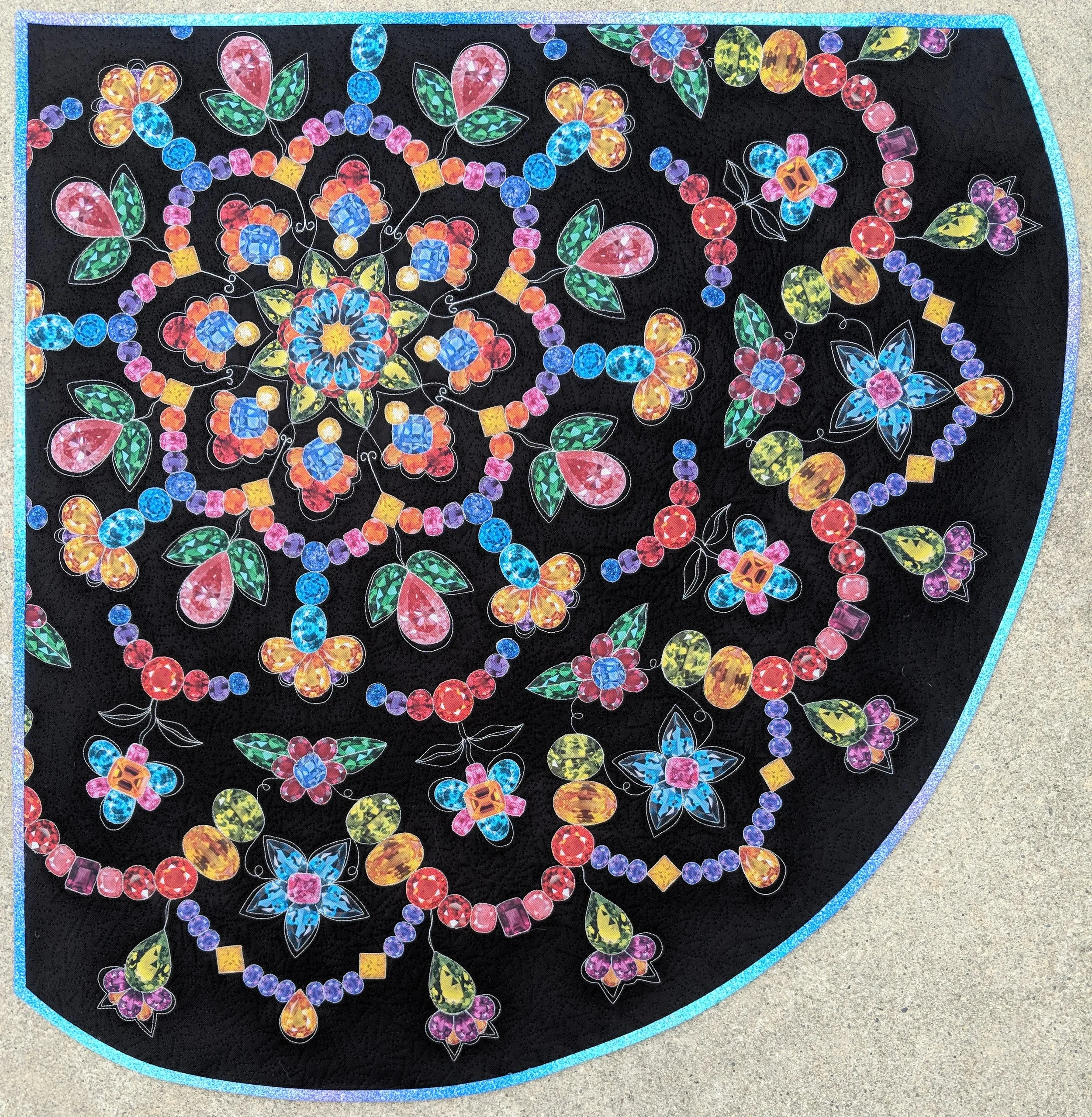 12. Sparkling Stained Glass Mandala June 2018 32” x 33” Made for the Hoffman Fabric Challenge. Challenge fabric featured jewels which were fussy cut out and laid out into a floral mosaic mandala design. Exhibits/Awards: Chosen at Hoffman’s Curator Choice for the Applique Category and is included in the Hoffman traveling exhibit (August 2018). Blog Post
