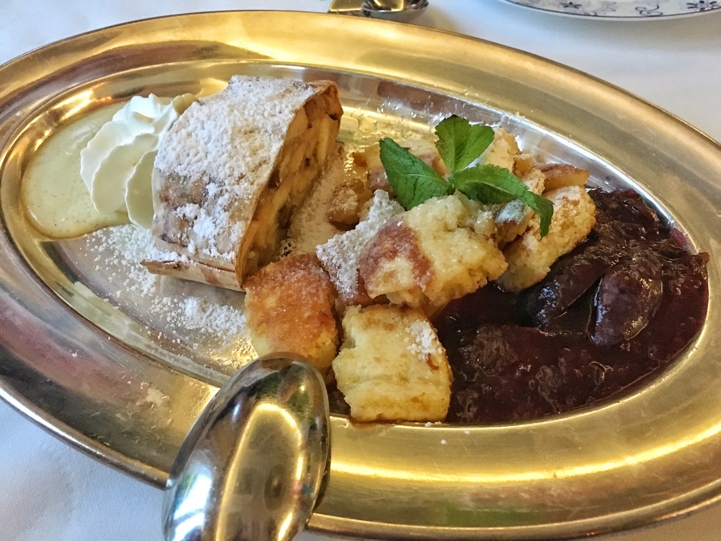 Homemade viennese apple strudel with vanilla sauce and whipped cream (Riesenradl & Stephansdom) and shredded pancake like cake with a plum compote (Kaiserschmarnn)