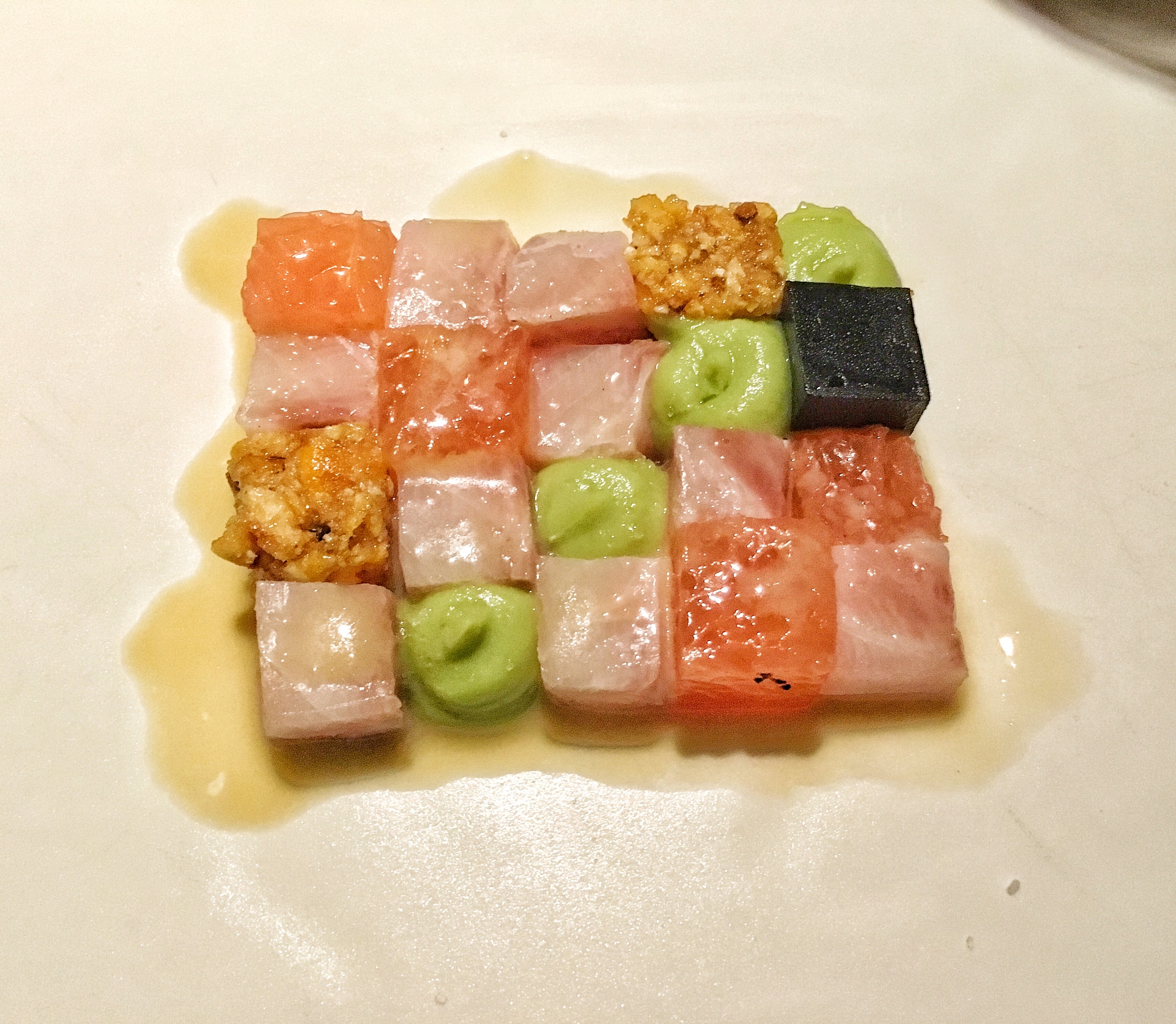 A chessboard of granola, wasabi, squid ink, grapefruit, tuna