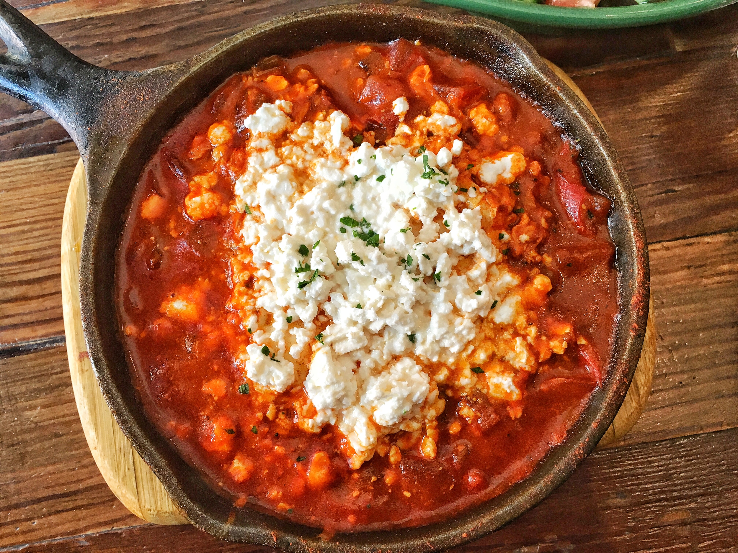 Close up of the 2 egg shakshuka with feta cheese in a spicy Moroccan tomato sauce
