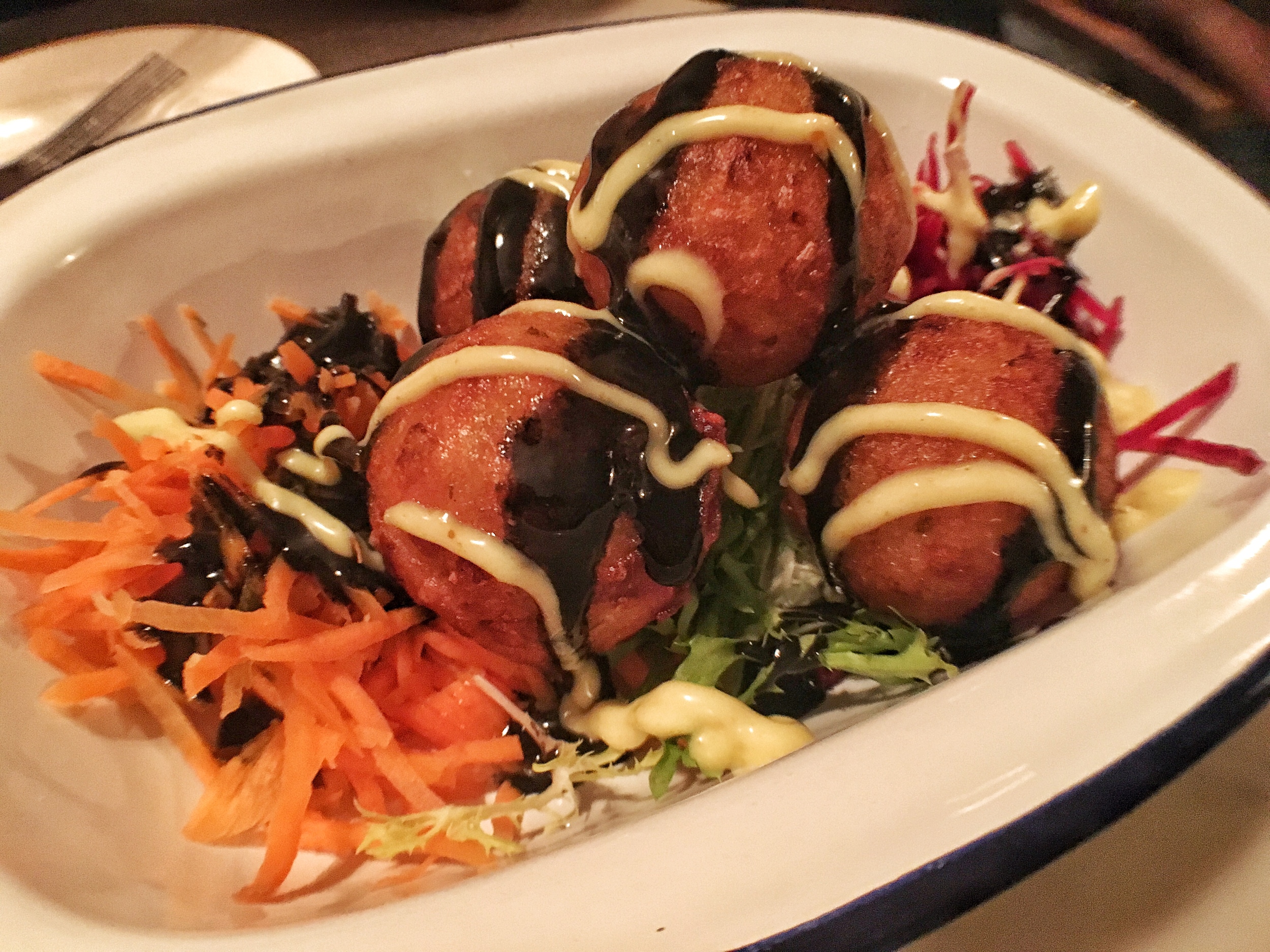 Octopus fritters with squid ink on slaw