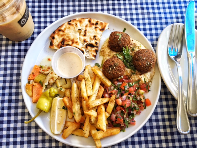 Falafel platter with fries, hummus, tomato salad, pickled vegetables, pita and tzatziki sauce