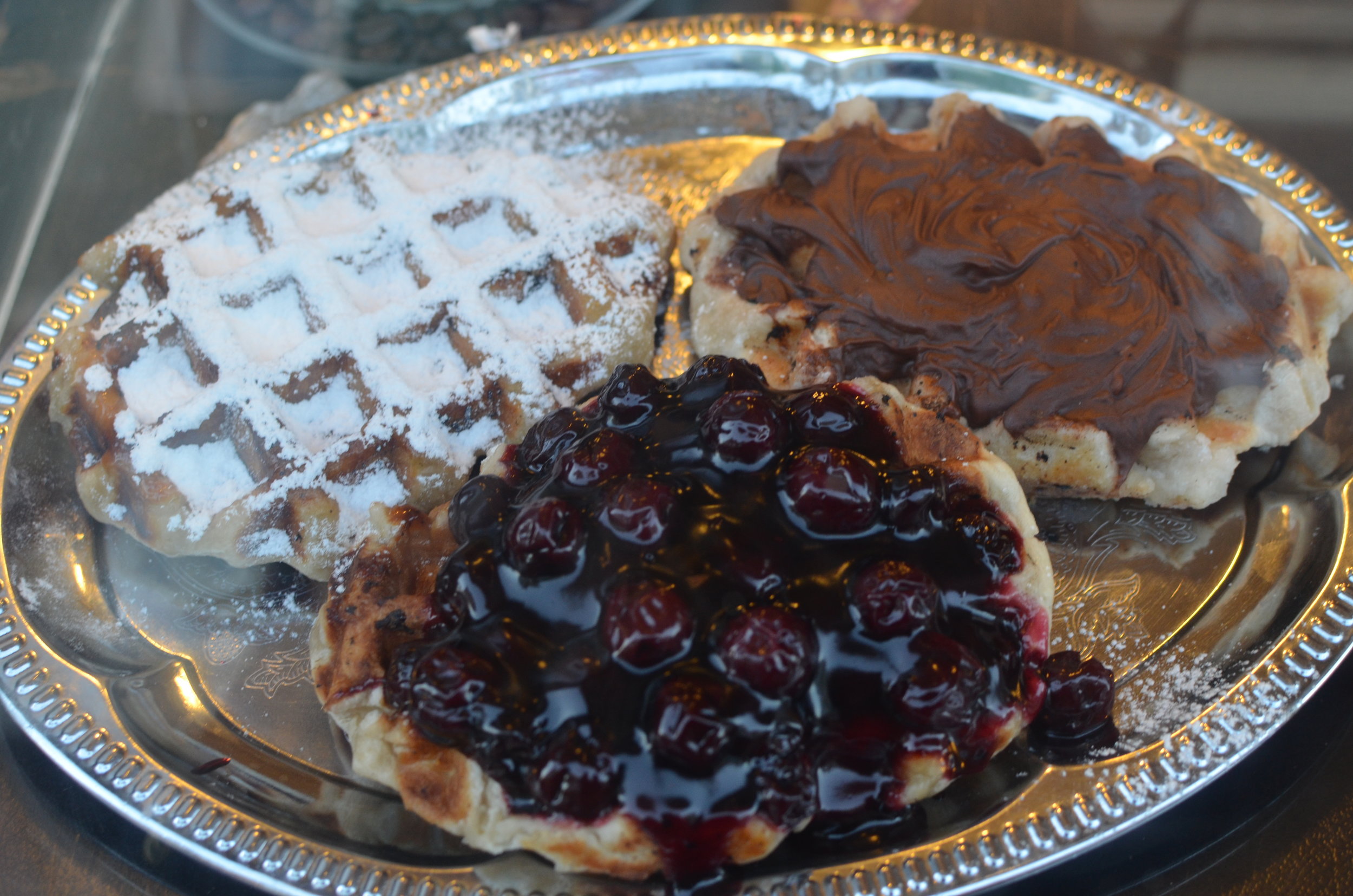 Waffles with powdered sugar, chocolate spread, jam
