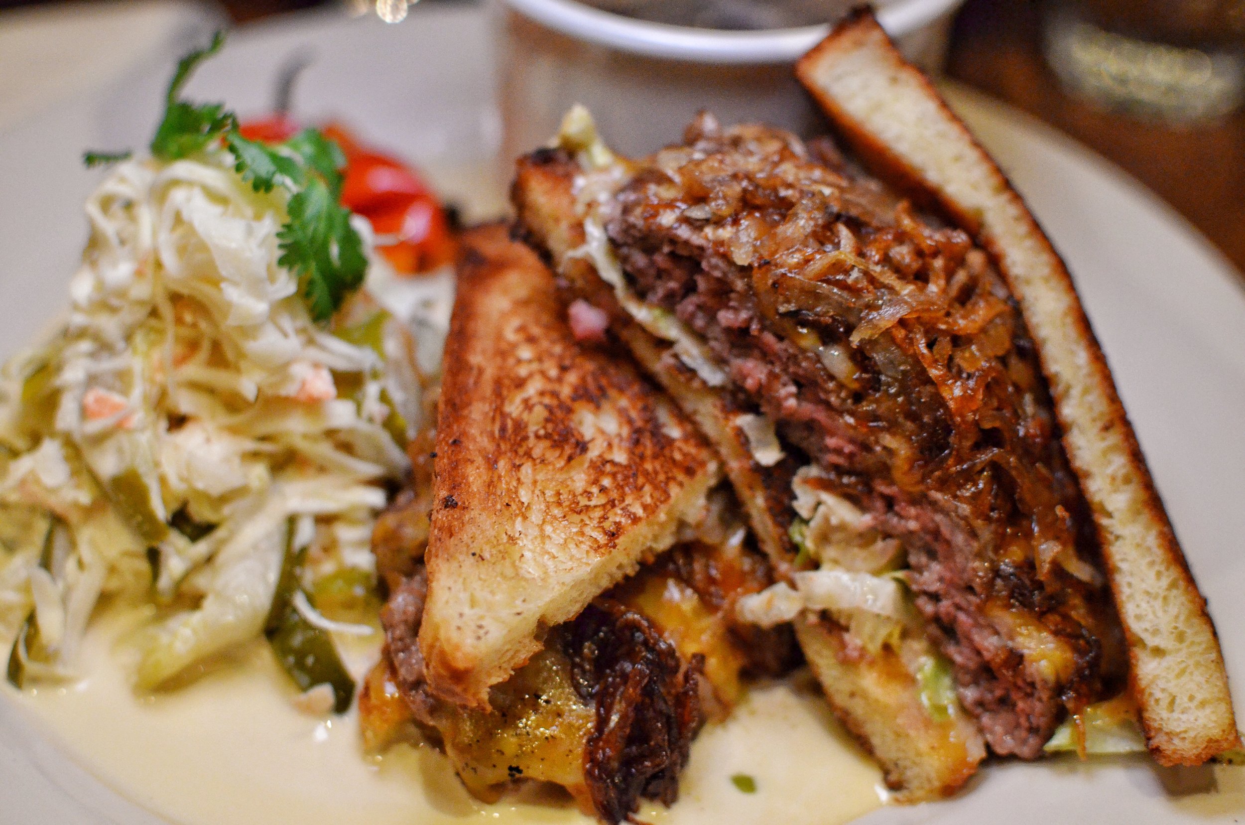 Patty melt on buttermilk bread, American cheese, Maison special sauce served with coleslaw and au jus