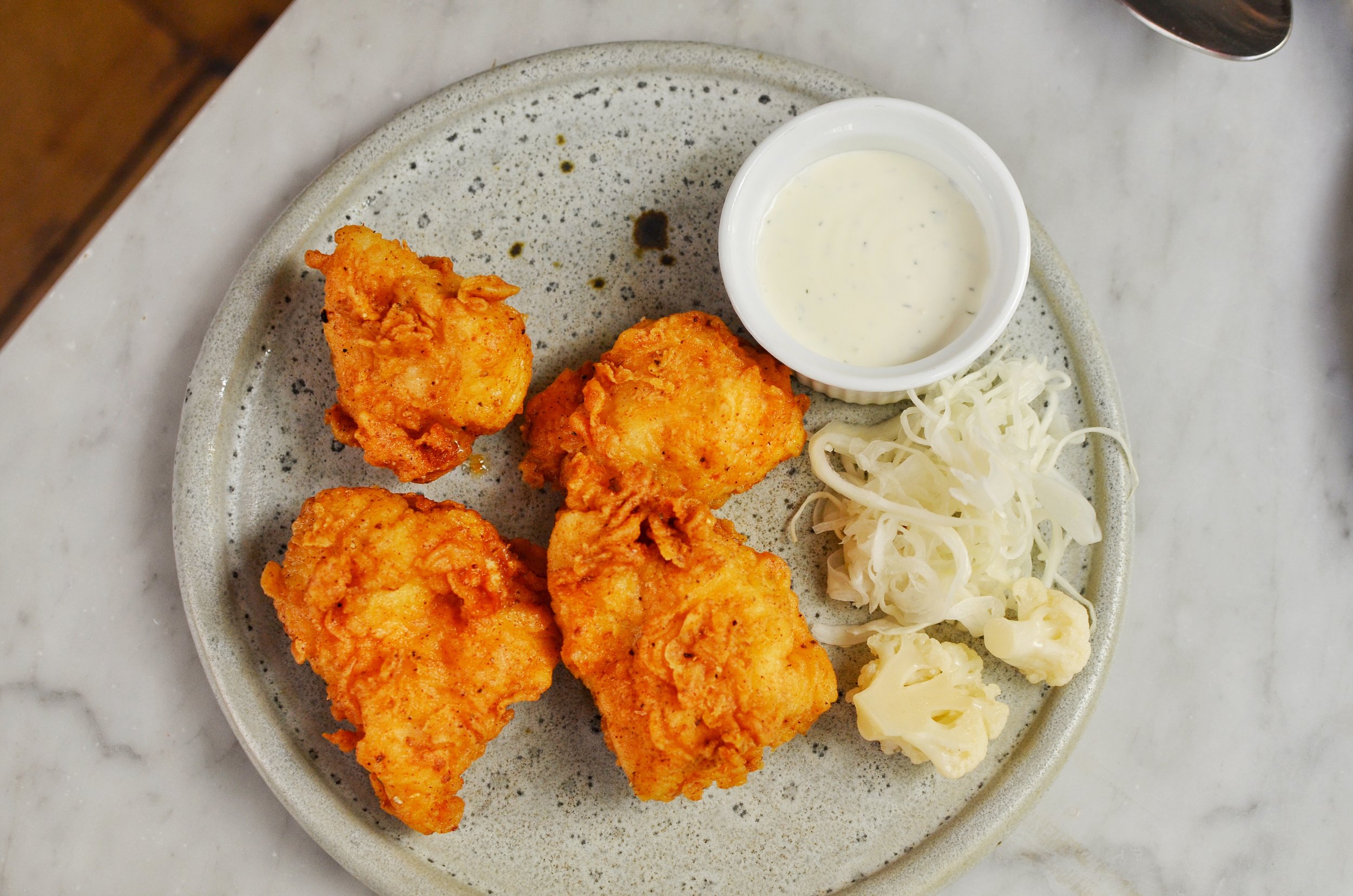 Fried chicken, pickles, cabbage- The chicken poppers are tender and juicy. The batter is also light so you won't feel overly stuffed after eating them.