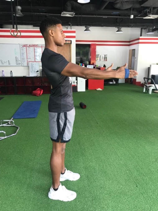 3. Raise both arms in front of you while keeping the the resistance band stretched.