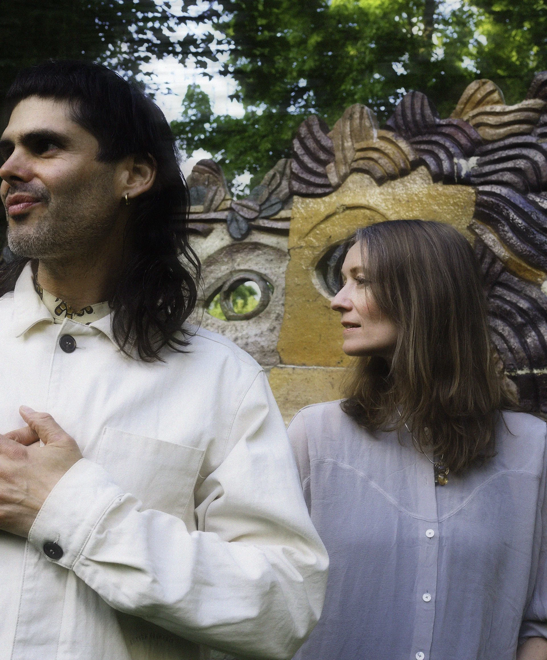 Erin Lang and Jorhito standing in front of some statues outside looking both to the right
