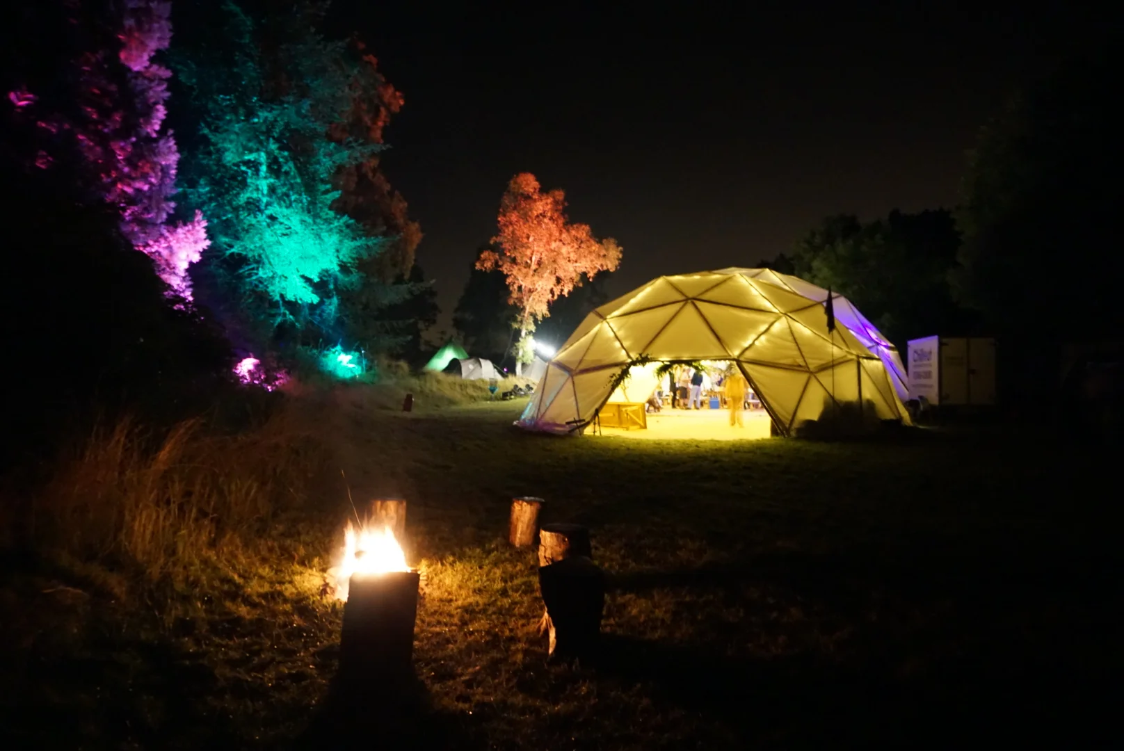 The exterior of an Atlas Domes geodome looking colourful at night.  This one was hired for a festival.