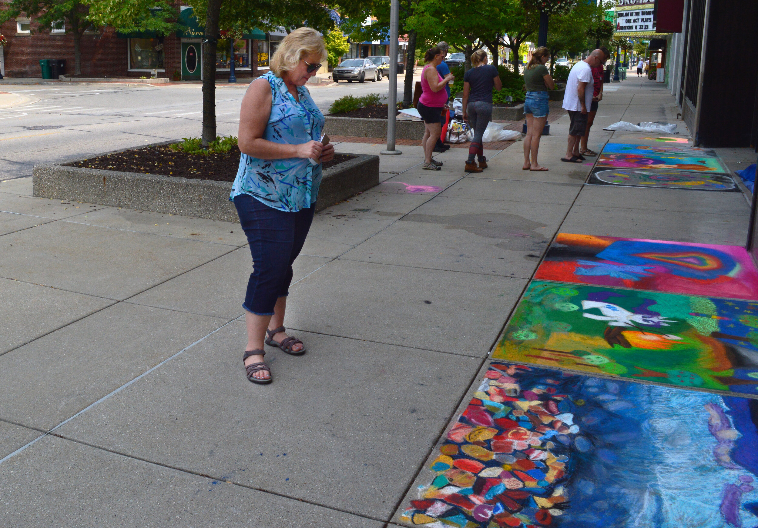 Patron looking at chalk art on the sidewalk during Art Walk Central