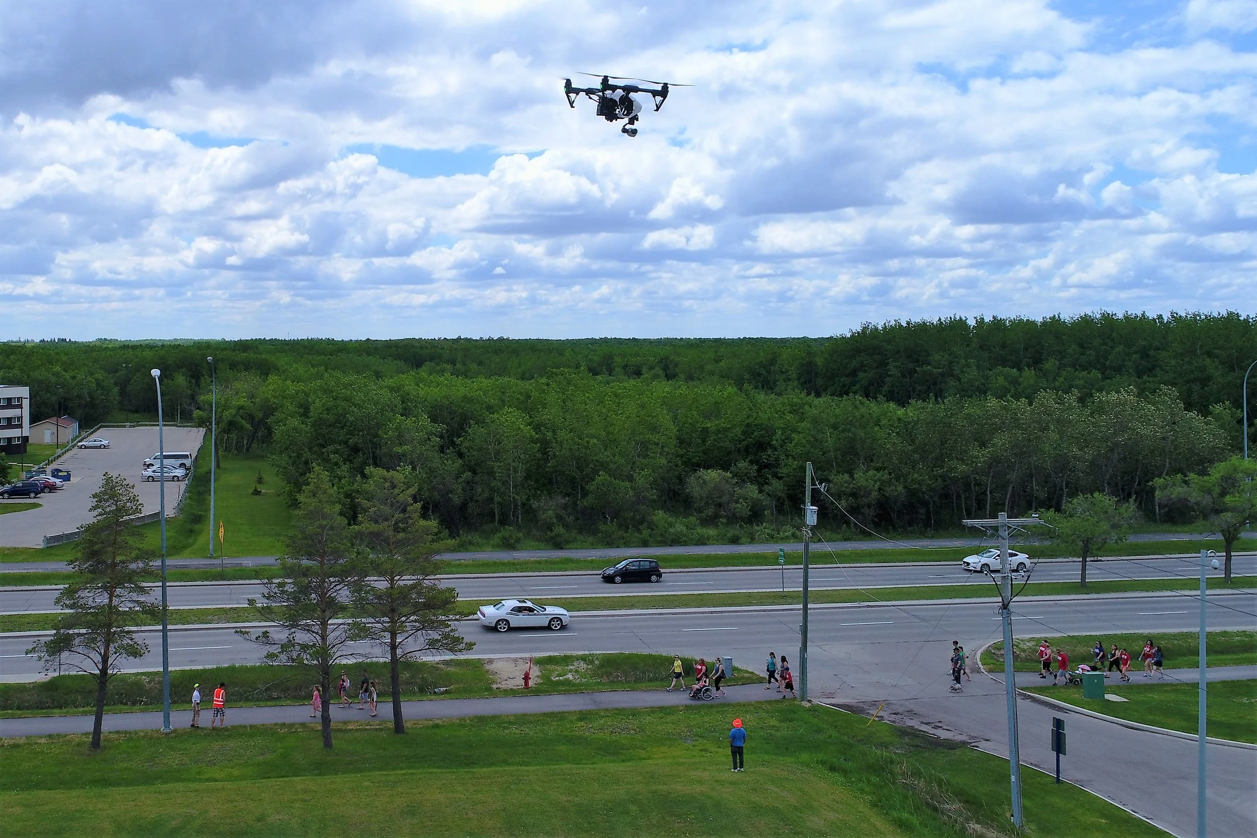 DJI Inspire 1 hovers safely over 100ft from any passers-by during the 2017 Crohn's & Colitis Canada Gutsy Walk at the Canadian Mennonite University. M3 Aerial Productions ground crew ensures a 100ft buffer between drone operations and the public.