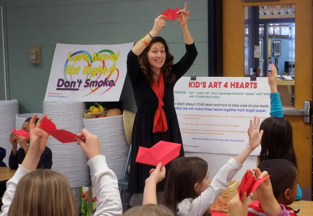Dr Cerel-Suhl teaching the first folds of the first of three origami heart; the second and third hearts are done by teams in a 21st Century Curriculum. January 2016. photo Lexington Herald-Leader, Tom Eblen