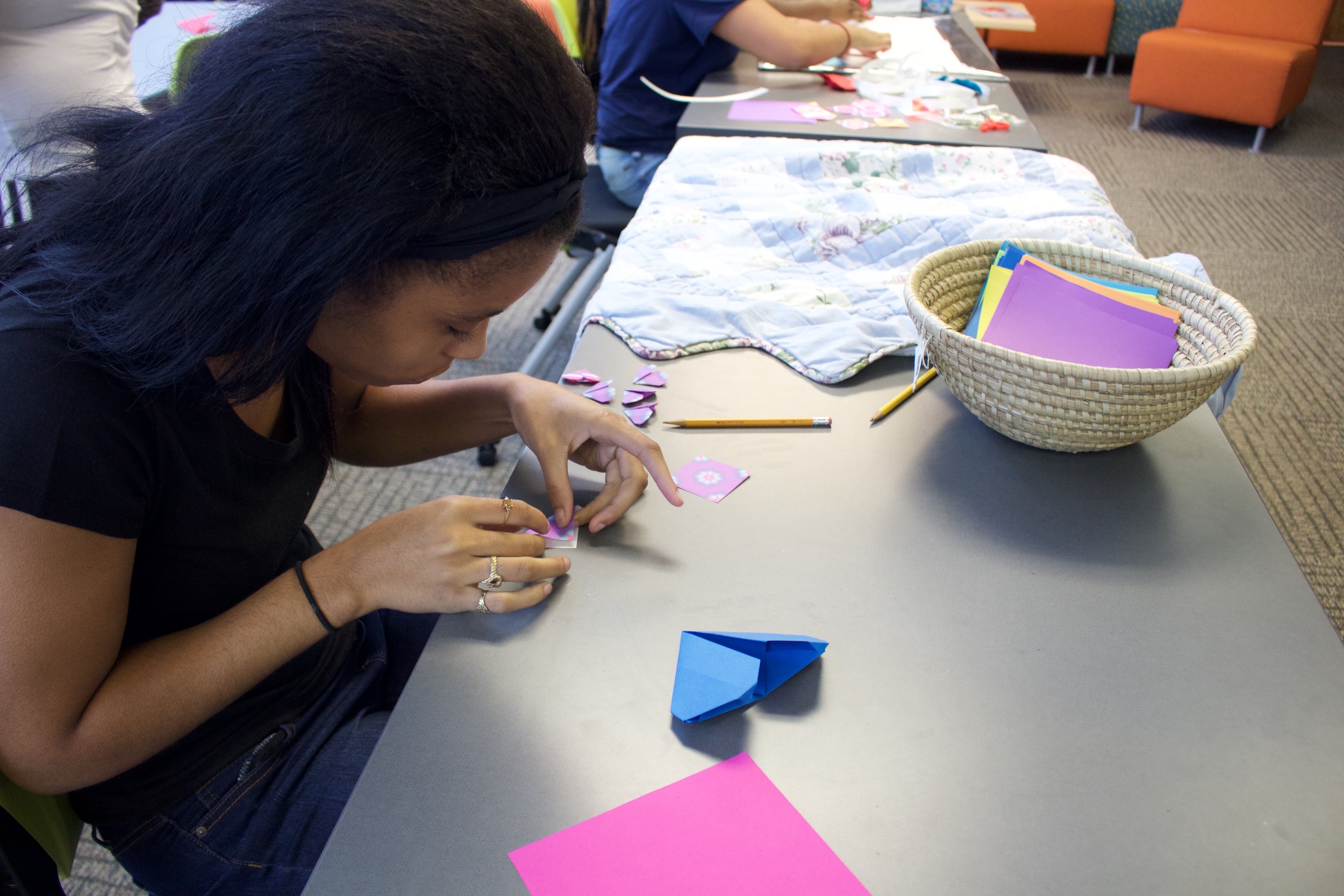 Family Care Center student making individual hearts for group project after origami and health lesson.
