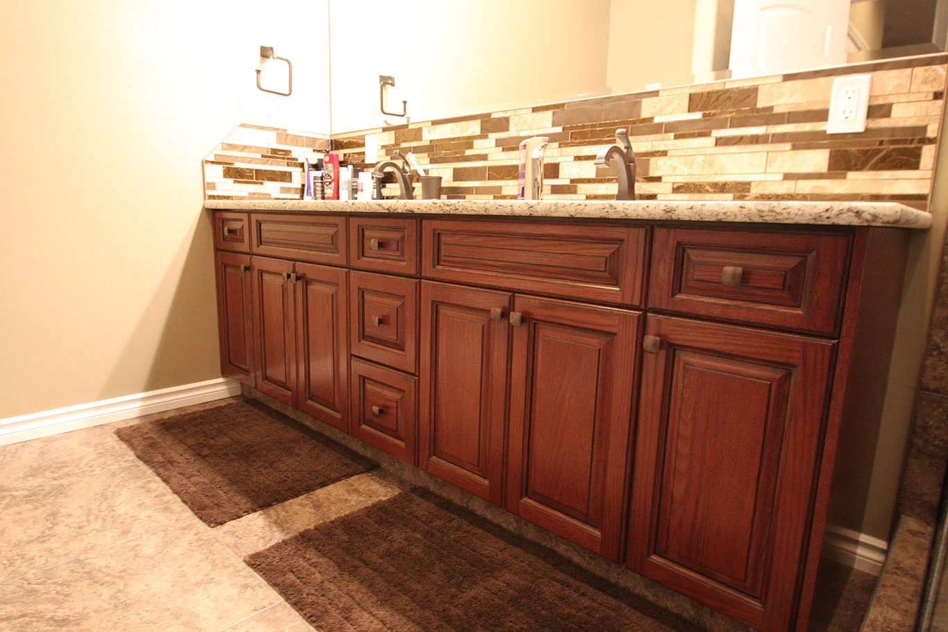 raised panel stained vanity with granite countertop