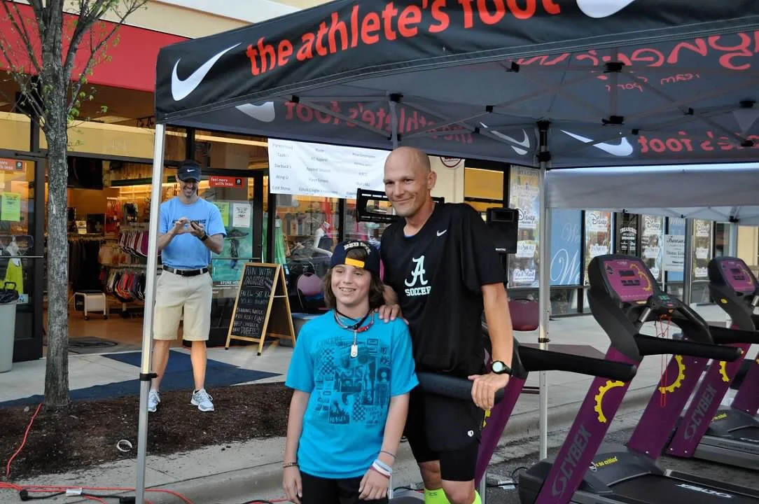 Cole and Mike Bissell stand together during the 100-mile treadmill fundraiser.