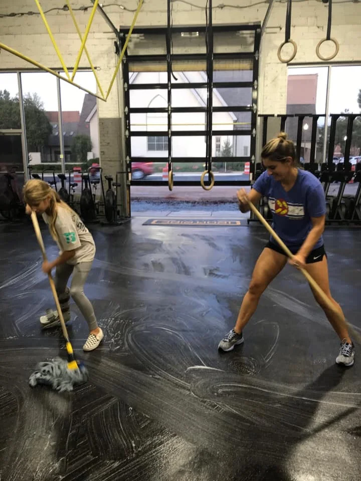 Arsenault and her daughter, Avery, mop the Iron Tribe Fitness floor together.