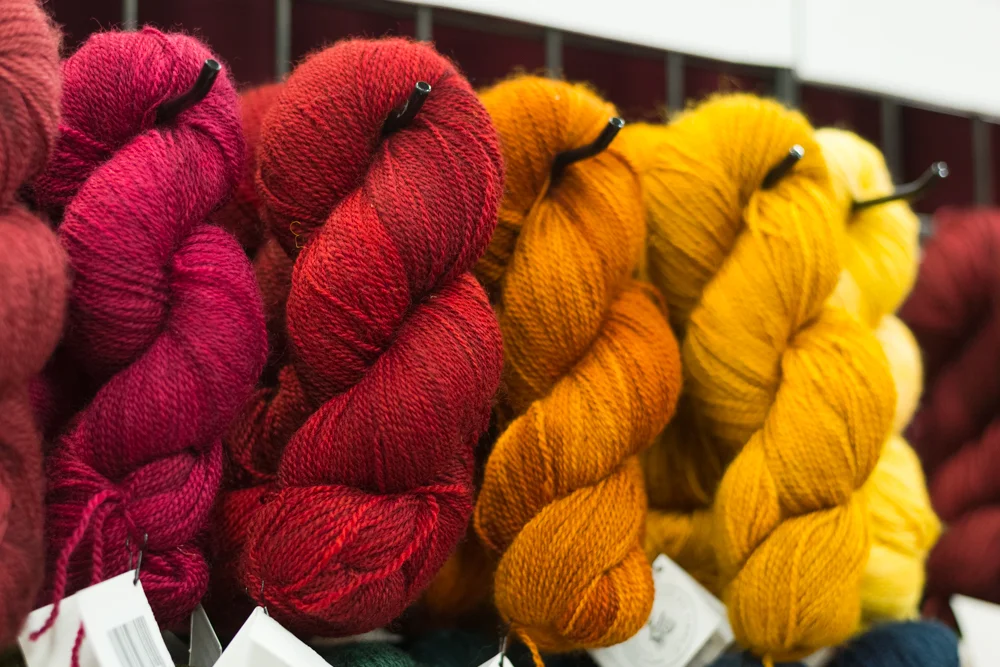 The Hollyberry is third from the left. This is where I blame the arena lighting because this photo does not capture the perfect orange-tinged redness of this yarn
