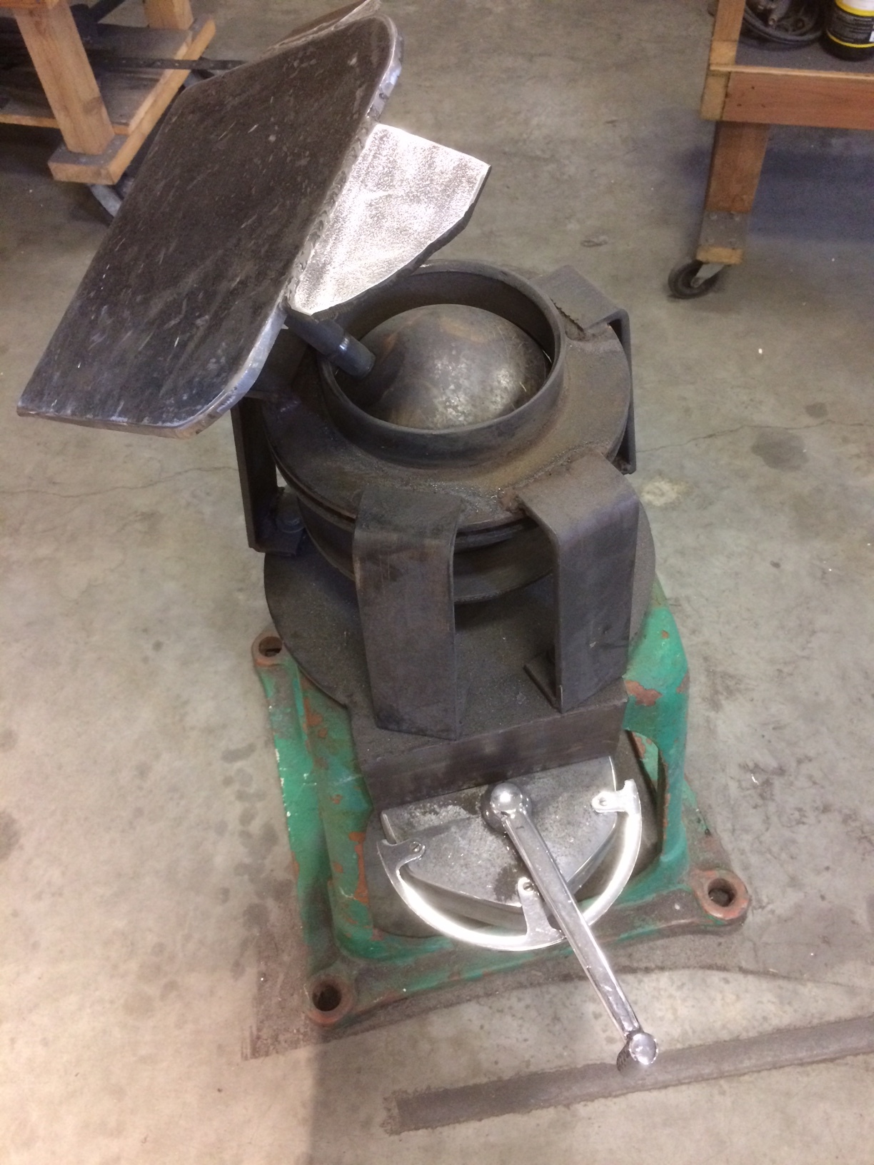 This is a little grinding table that I made for grinding sculptures. the table rotates on a bowling ball and a pneumatic cylinder locks the ball in place by pinching it between two brake discs. The cylinder is actuated by a throttle control that came from the Coast Guard ship Alex Haley. It might be a bit more convenient to have a foot control, but the chrome handle is just too cool to not use.