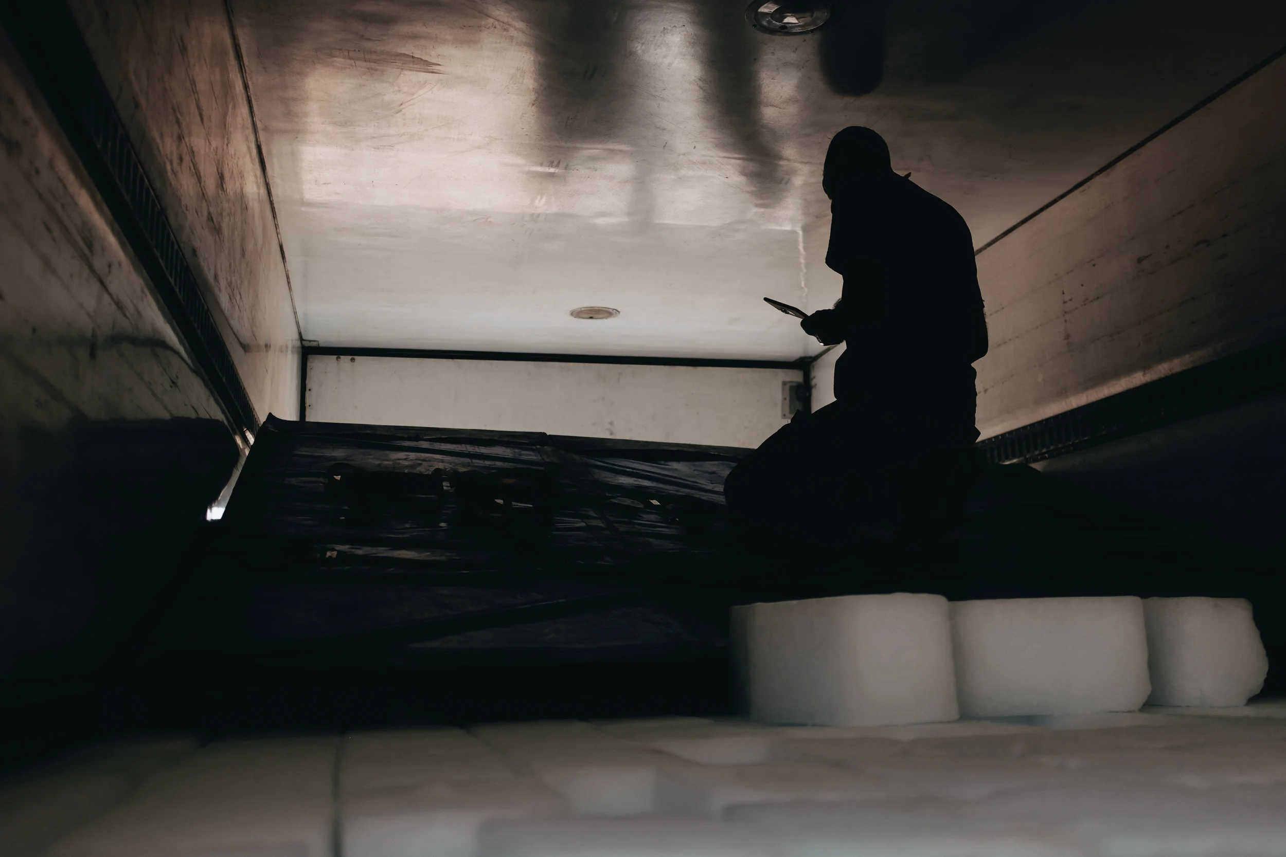 Mohammed, a team leader for the Wasel Tasel team, a local NGO, manages the logistics of aid distrobutions from the back of a refregerated truck containing thousands of blocks of ice to be given to the residents of IDP camps around Mosul.